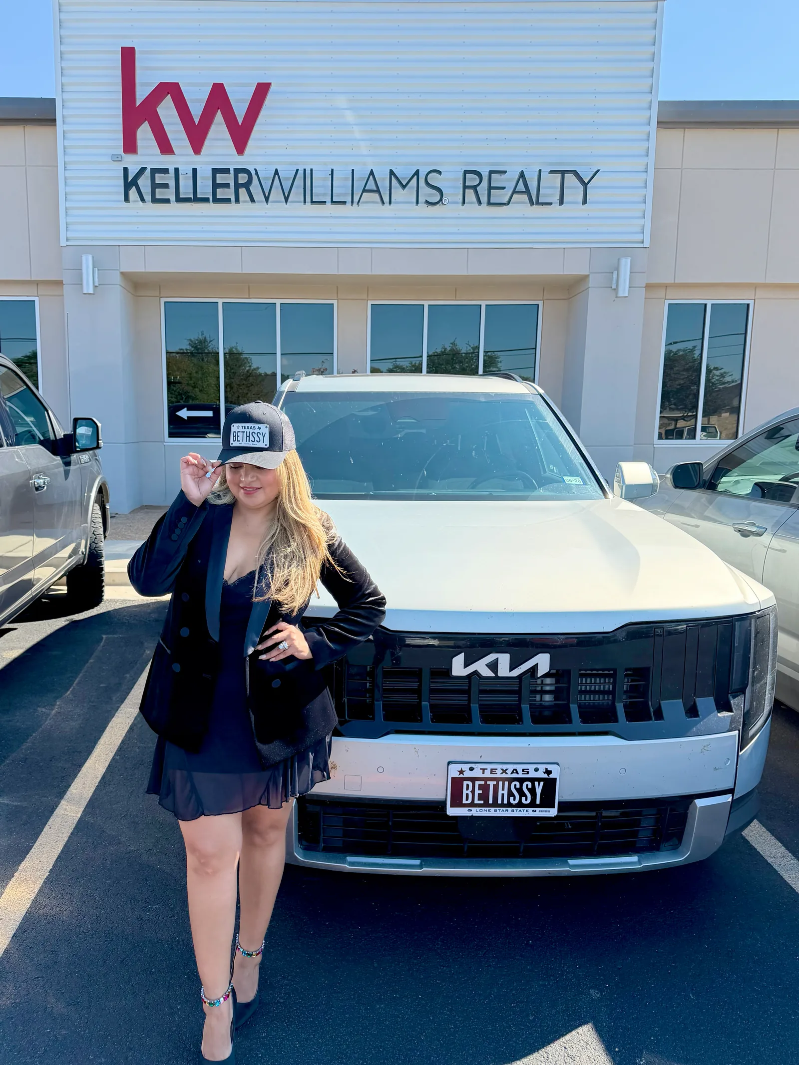 Bethssy en la oficina de Keller Williams Realty junto a su camioneta con la placa BETHSSY